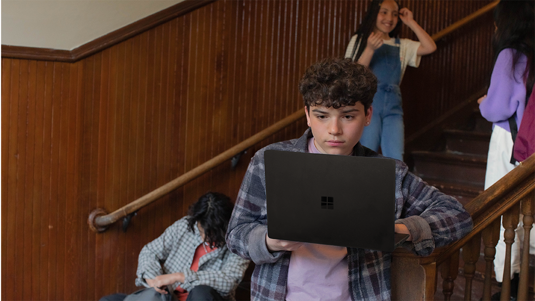 Male and female students gathered in a stairwell using back-to-school tech