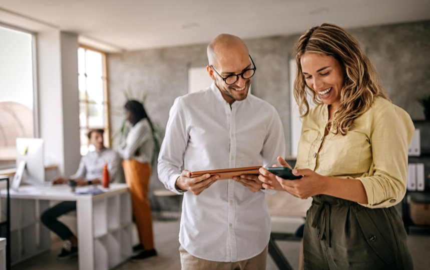 Man and woman reviewing and laughing in office