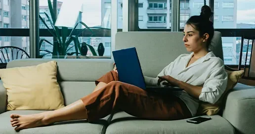 A person lounging at home, while on a laptop