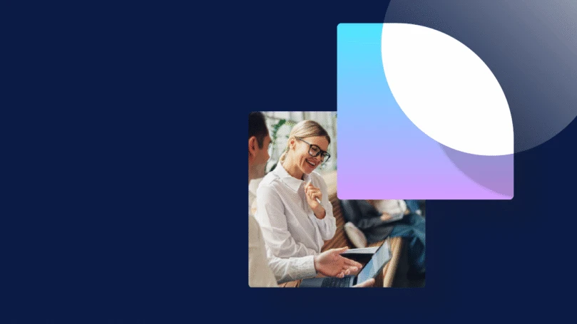 Coworkers sit on a bench in an atrium discussing a new project.